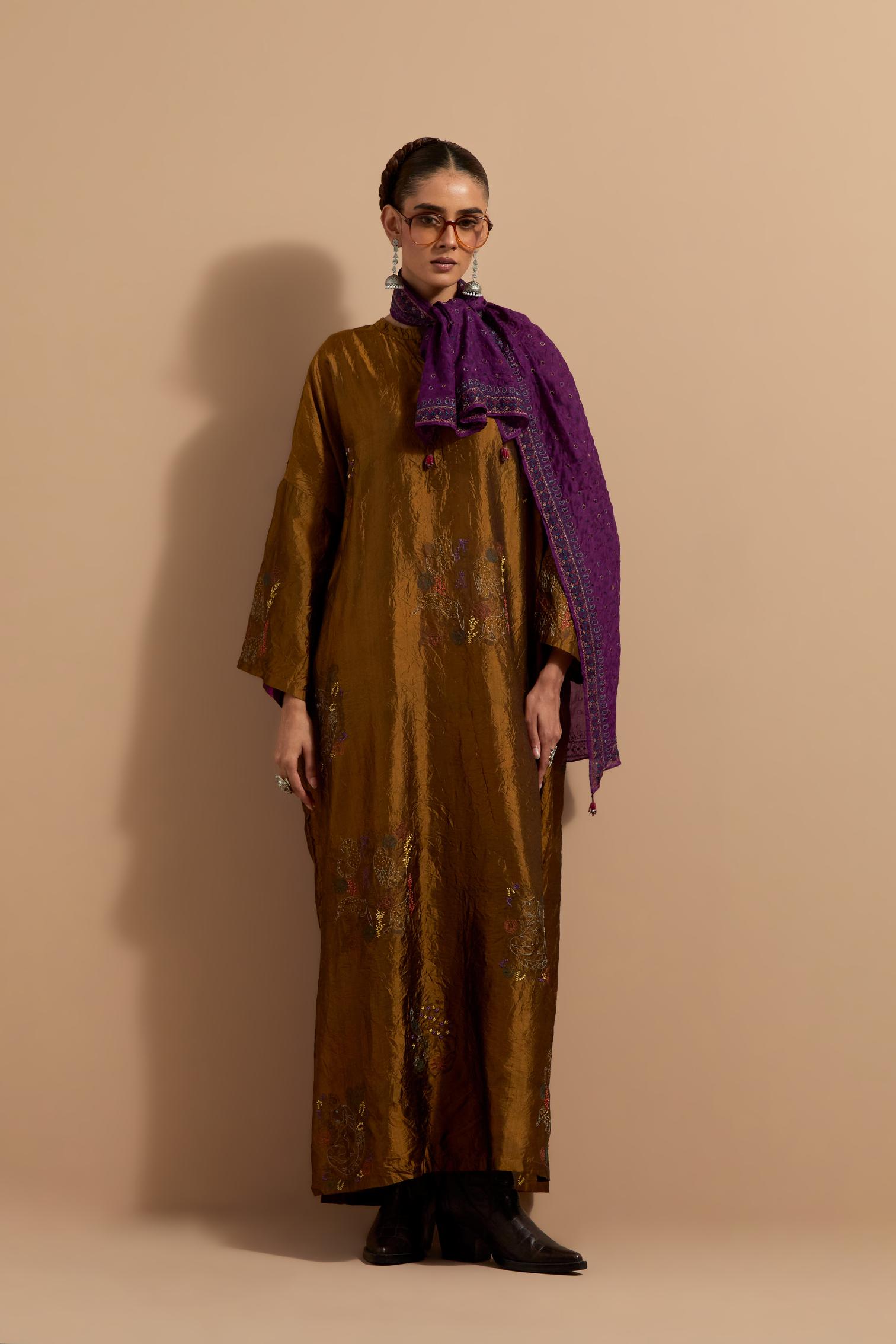 Olive crushed silk hand block printed long kaftan, highlighted with multi colored thread embroidery, paired with Red hand crushed block printed silk stole with quilted embroidery and beaded tassels.