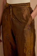 Olive crushed silk hand block printed pants, highlighted with multi colored thread embroidery.