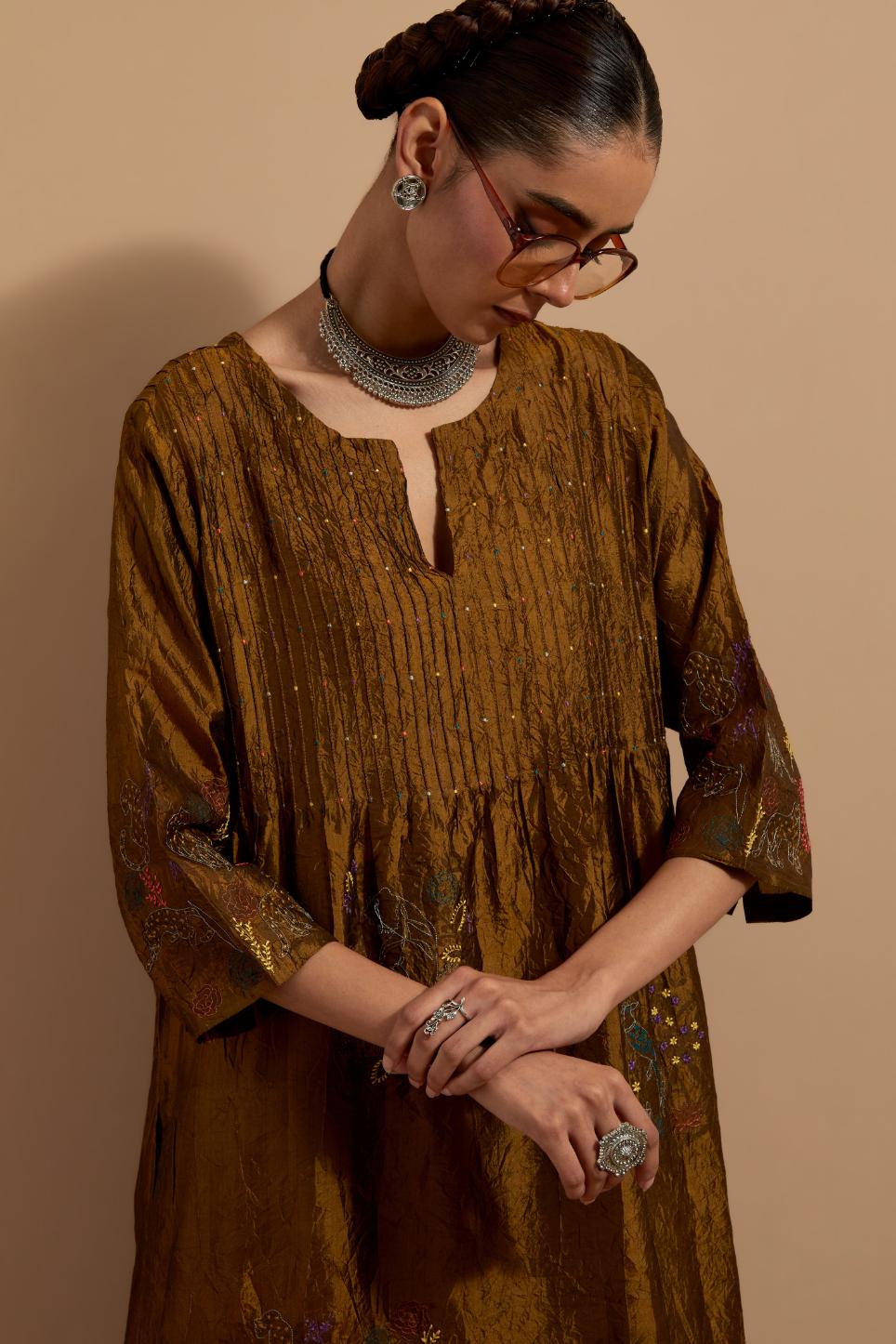 Olive crushed silk hand block printed kurta set with pin tucks at yoke, highlighted with multi colored thread embroidery.