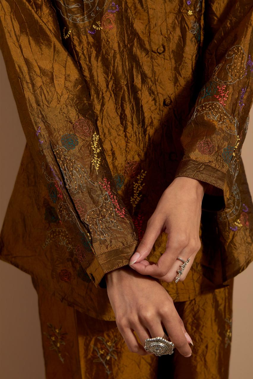 Olive crushed silk hand block printed shirt, highlighted with multi colored thread embroidery, paired with Olive crushed silk hand block printed pants, highlighted with multi colored thread embroidery.