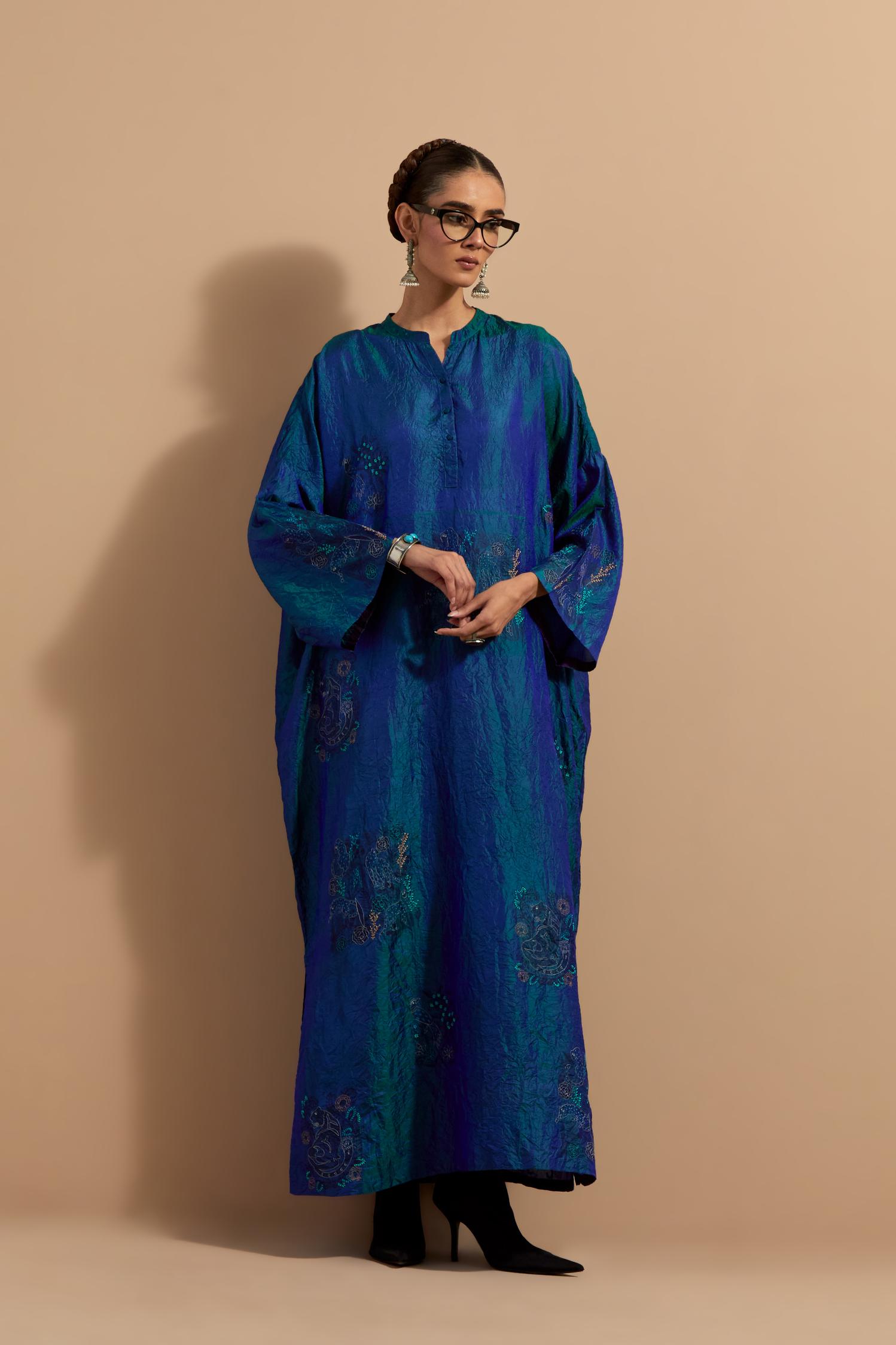 Teal blue crushed silk hand block printed long kaftan, highlighted with multi colored thread embroidery, paired with Red hand crushed block printed silk stole with quilted embroidery and beaded tassels.