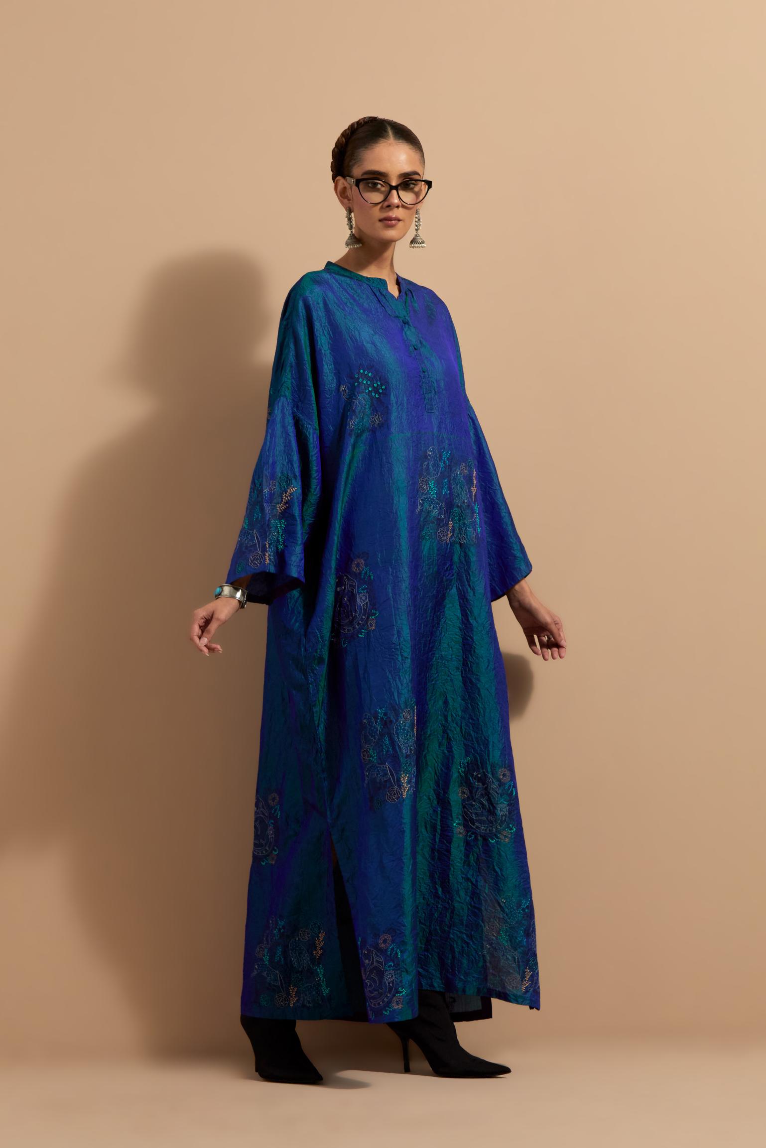 Teal blue crushed silk hand block printed long kaftan, highlighted with multi colored thread embroidery, paired with Red hand crushed block printed silk stole with quilted embroidery and beaded tassels.