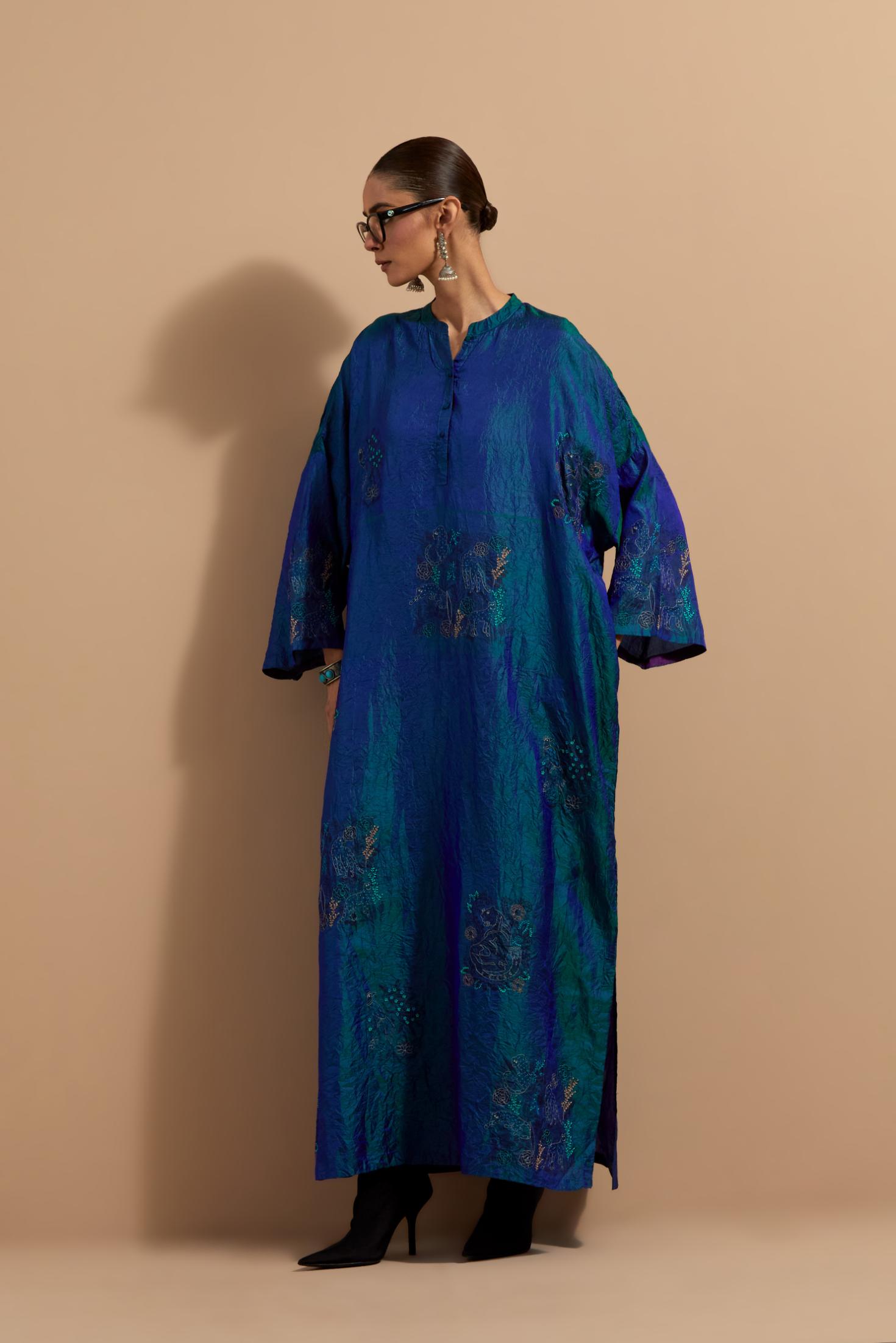 Teal blue crushed silk hand block printed long kaftan, highlighted with multi colored thread embroidery, paired with Red hand crushed block printed silk stole with quilted embroidery and beaded tassels.