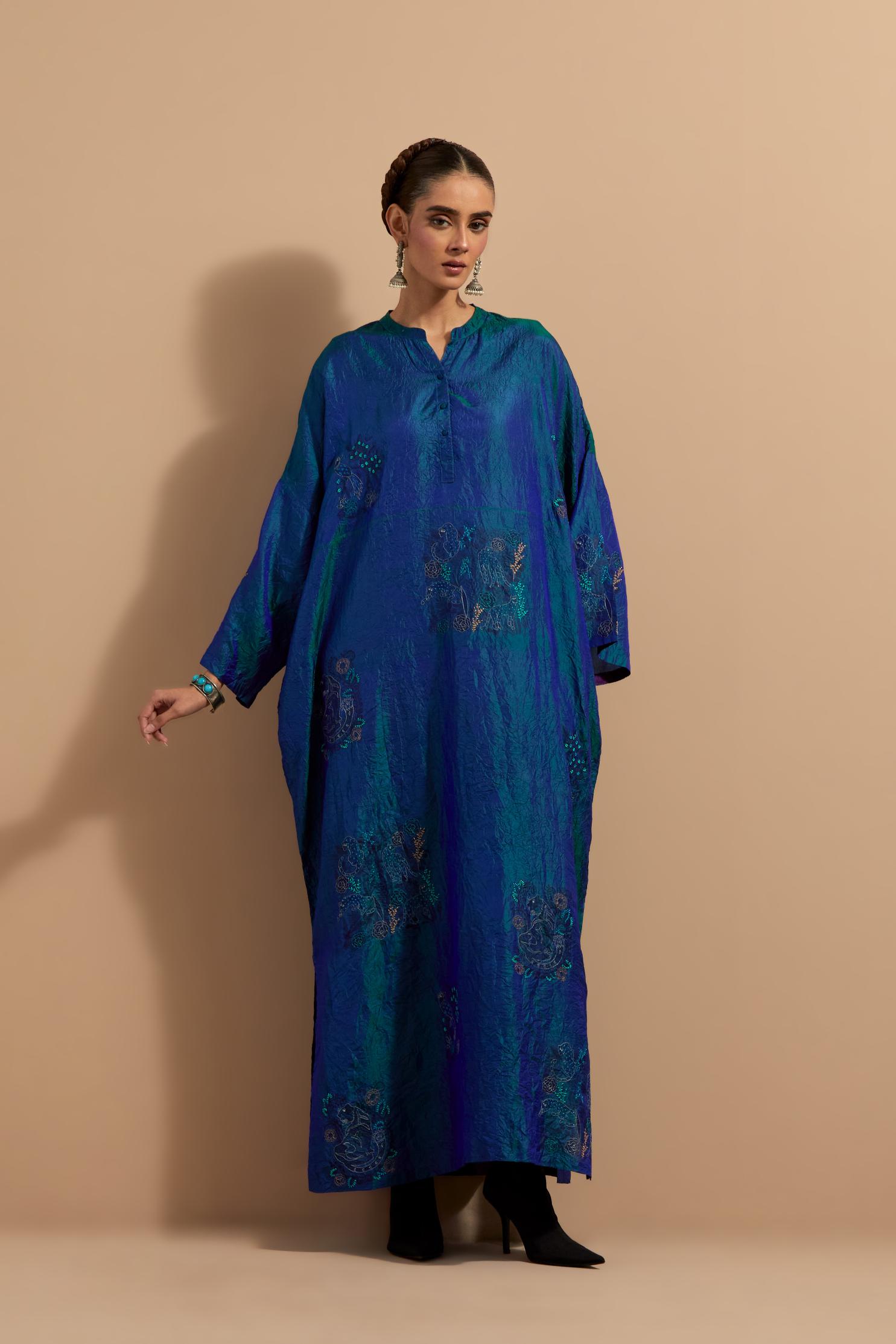 Teal blue crushed silk hand block printed long kaftan, highlighted with multi colored thread embroidery, paired with Red hand crushed block printed silk stole with quilted embroidery and beaded tassels.