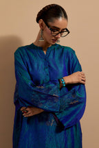 Teal blue crushed silk hand block printed long kaftan, highlighted with multi colored thread embroidery, paired with Red hand crushed block printed silk stole with quilted embroidery and beaded tassels.