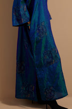 Teal blue crushed silk hand block printed long kaftan, highlighted with multi colored thread embroidery, paired with Red hand crushed block printed silk stole with quilted embroidery and beaded tassels.