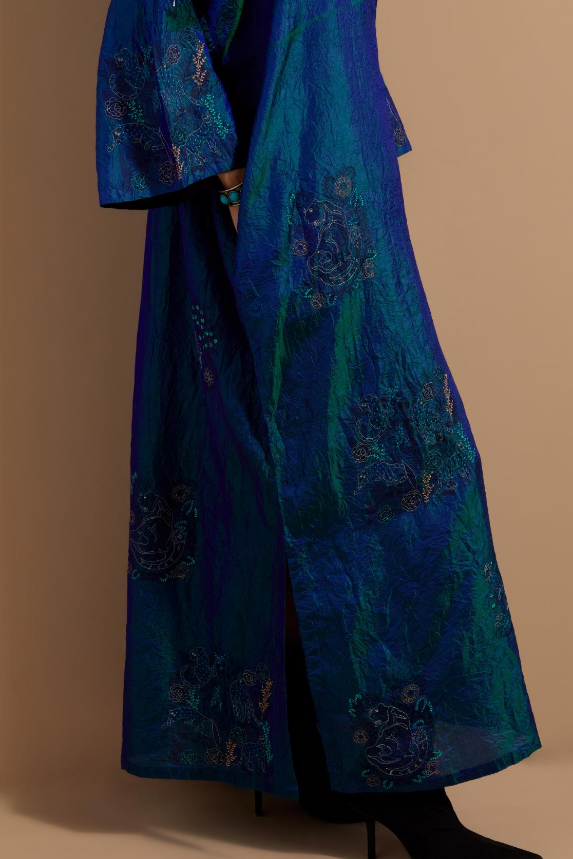 Teal blue crushed silk hand block printed long kaftan, highlighted with multi colored thread embroidery, paired with Red hand crushed block printed silk stole with quilted embroidery and beaded tassels.