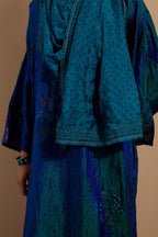 Teal blue crushed silk hand block printed long kaftan, highlighted with multi colored thread embroidery, paired with Red hand crushed block printed silk stole with quilted embroidery and beaded tassels.