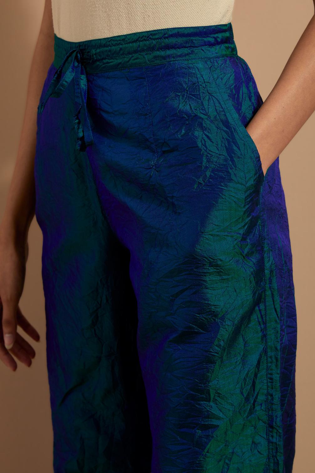 Teal blue crushed silk hand block printed pants with pin tucks detailing at hem.