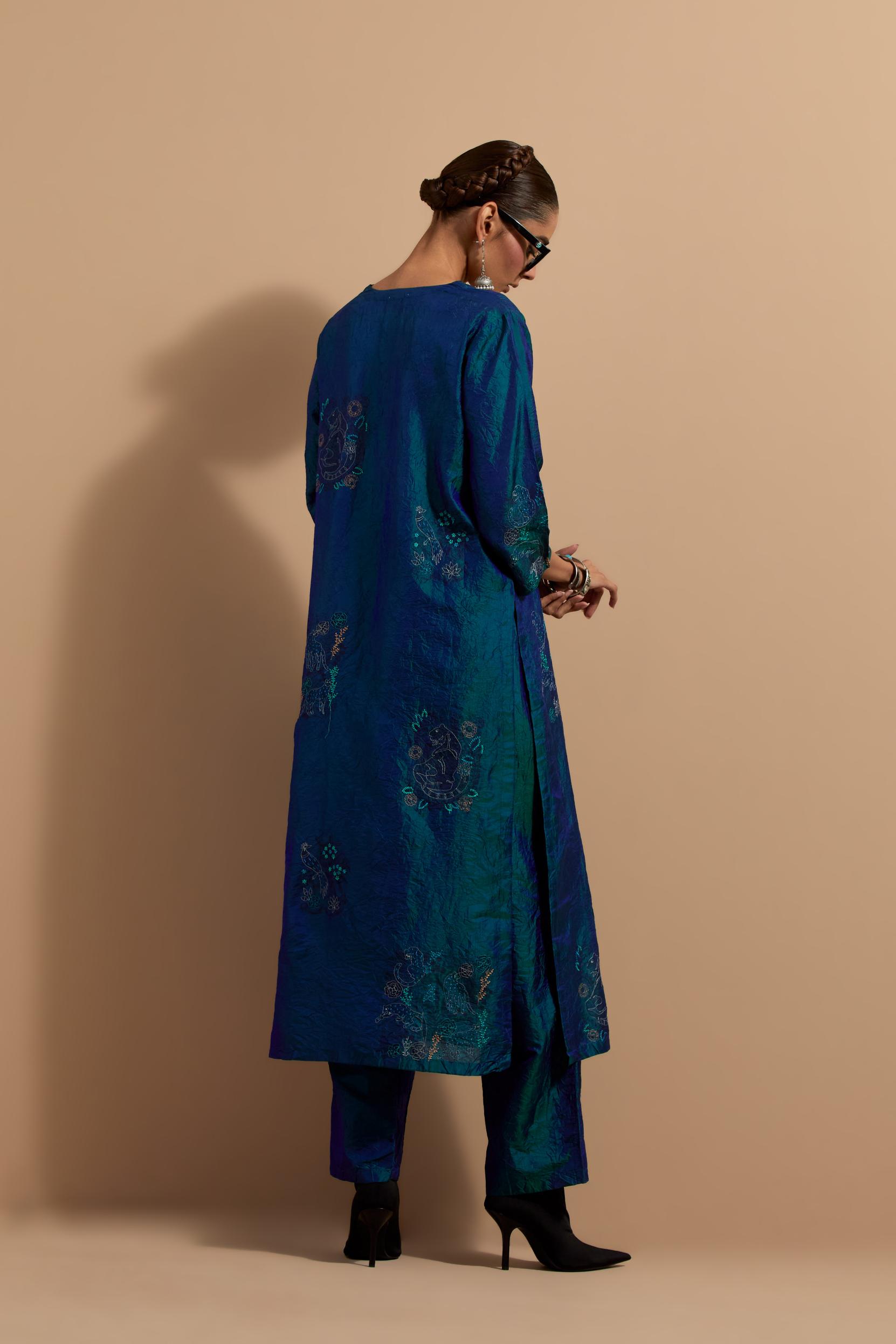 Teal blue crushed silk hand block printed straight kurta set, highlighted with multi colored thread embroidery.