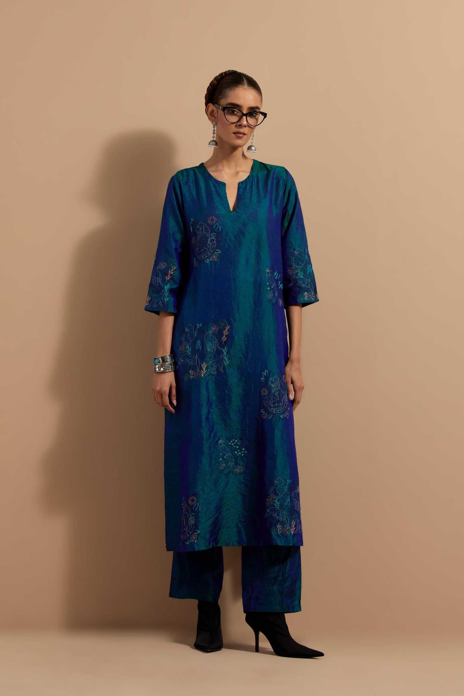 Teal blue crushed silk hand block printed straight kurta set, highlighted with multi colored thread embroidery.