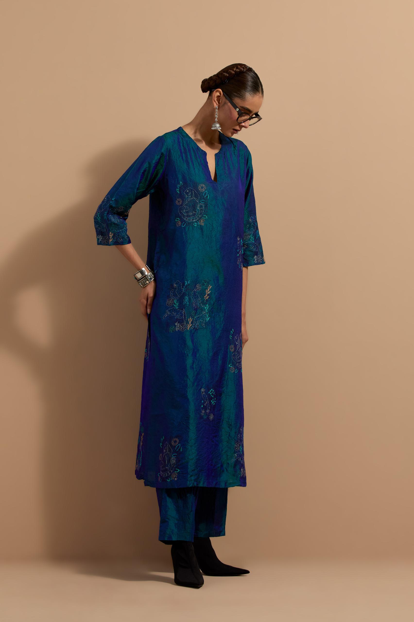 Teal blue crushed silk hand block printed straight kurta set, highlighted with multi colored thread embroidery.