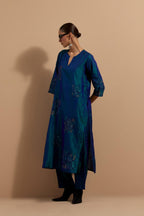 Teal blue crushed silk hand block printed straight kurta set, highlighted with multi colored thread embroidery.