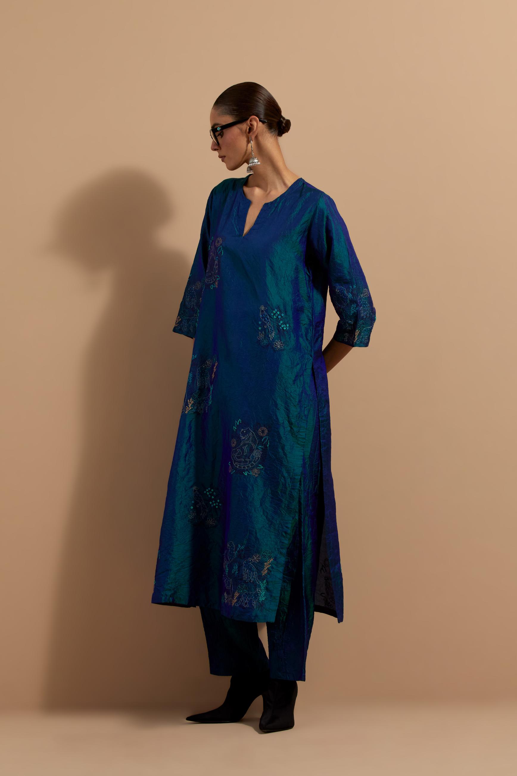 Teal blue crushed silk hand block printed straight kurta set, highlighted with multi colored thread embroidery.