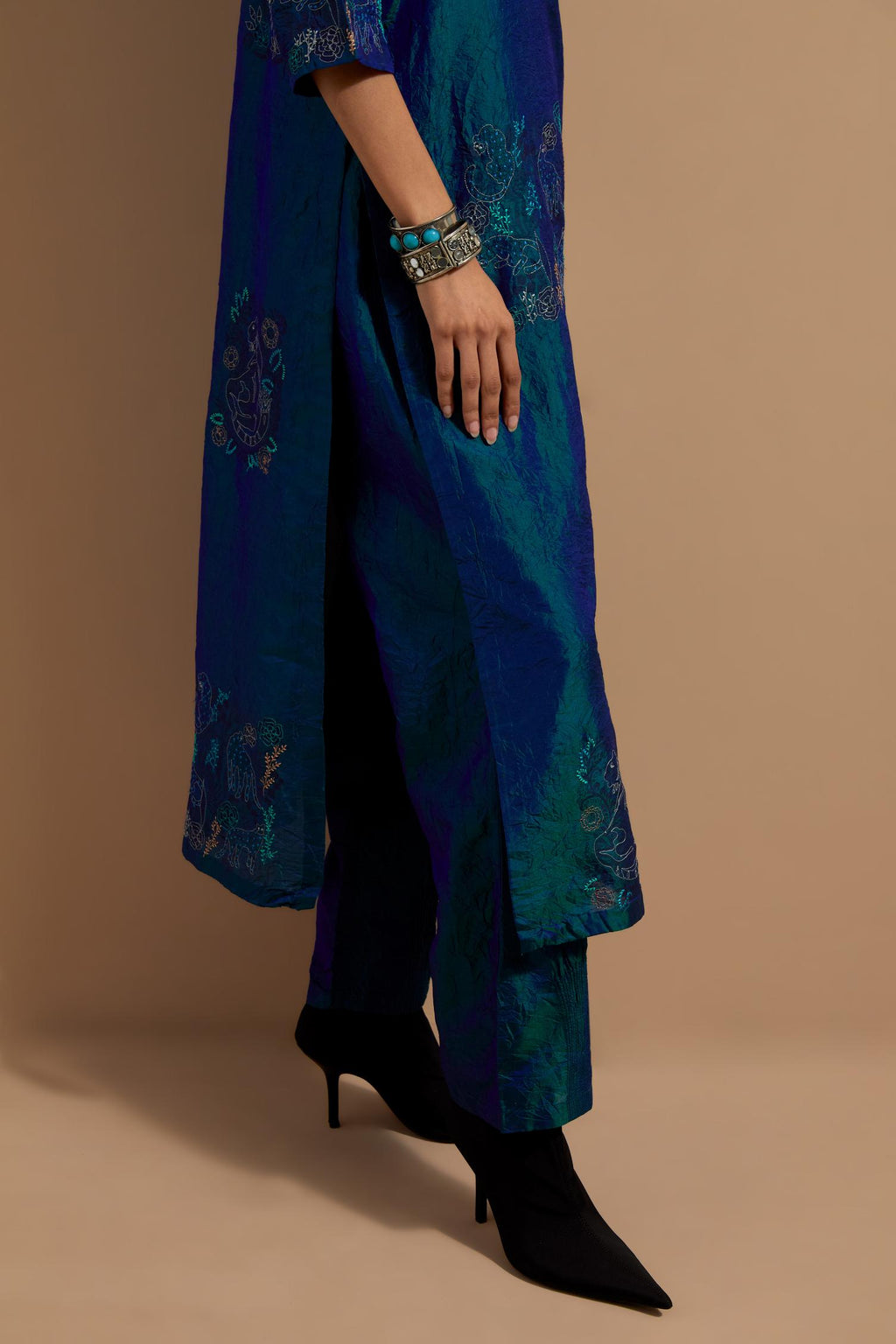 Teal blue crushed silk hand block printed straight kurta set, highlighted with multi colored thread embroidery.