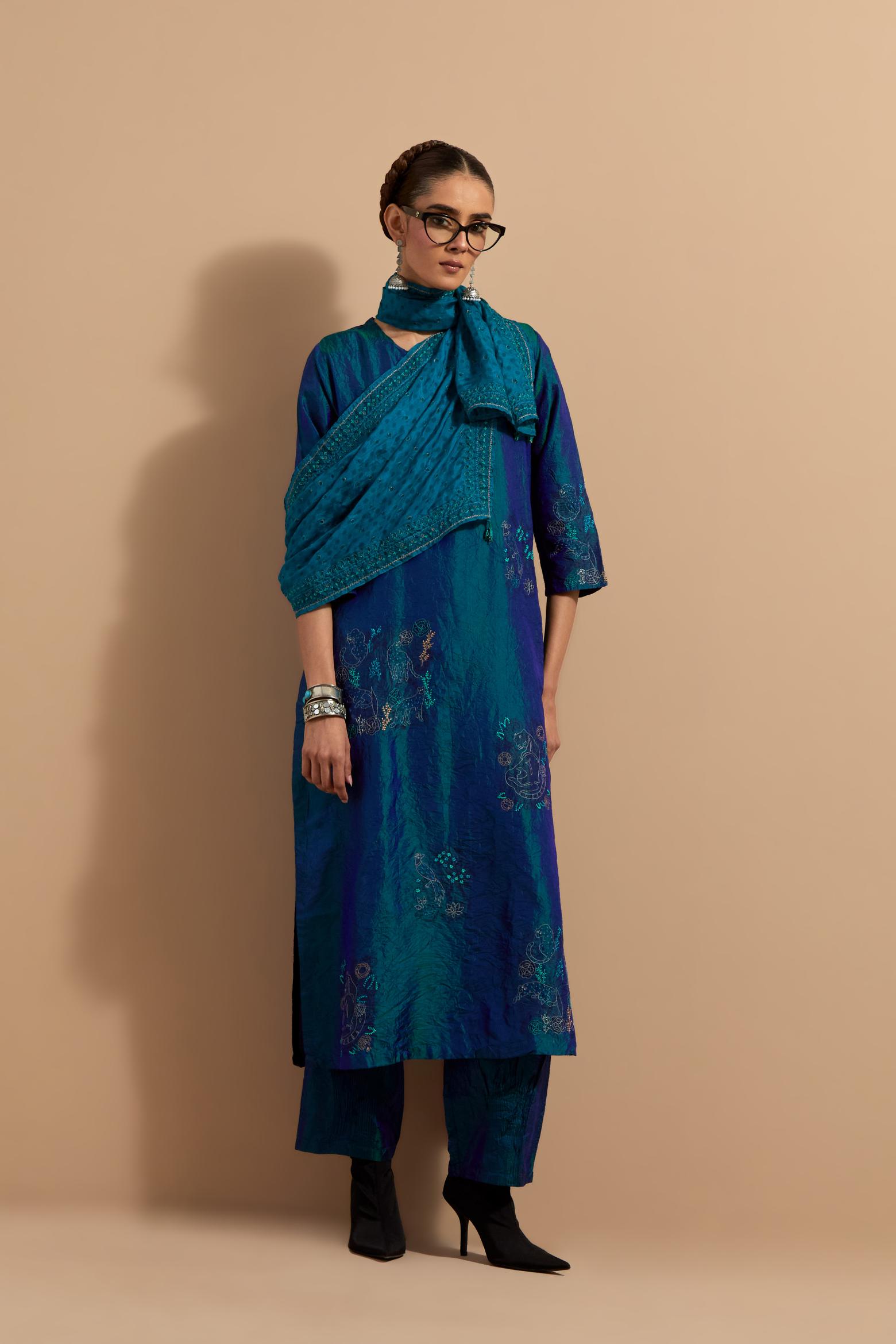 Teal blue crushed silk hand block printed straight kurta set, highlighted with multi colored thread embroidery.