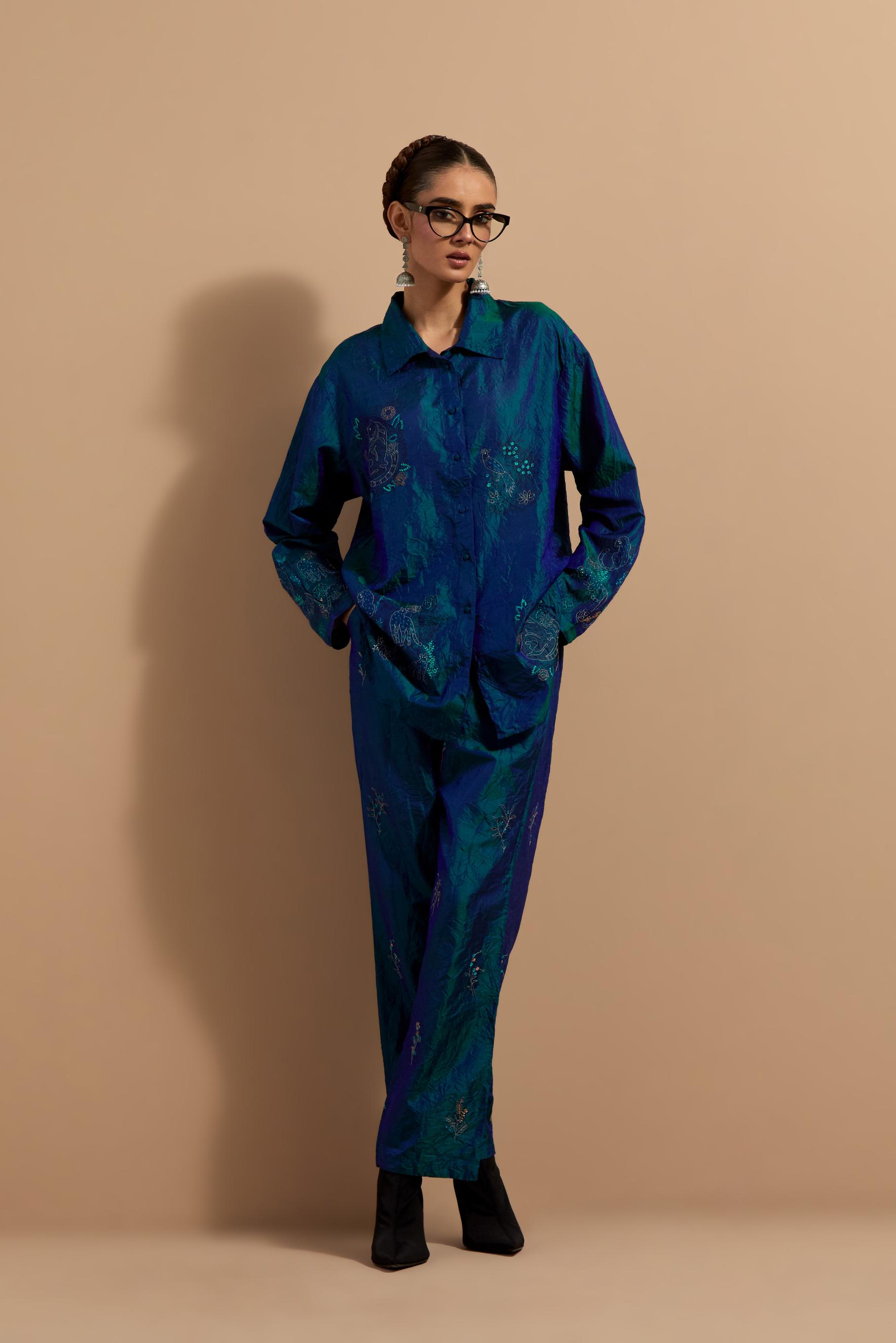 Teal blue crushed silk hand block printed shirt, highlighted with multi colored thread embroidery, paired with Teal blue crushed silk hand block printed pants, highlighted with multi colored thread embroidery.