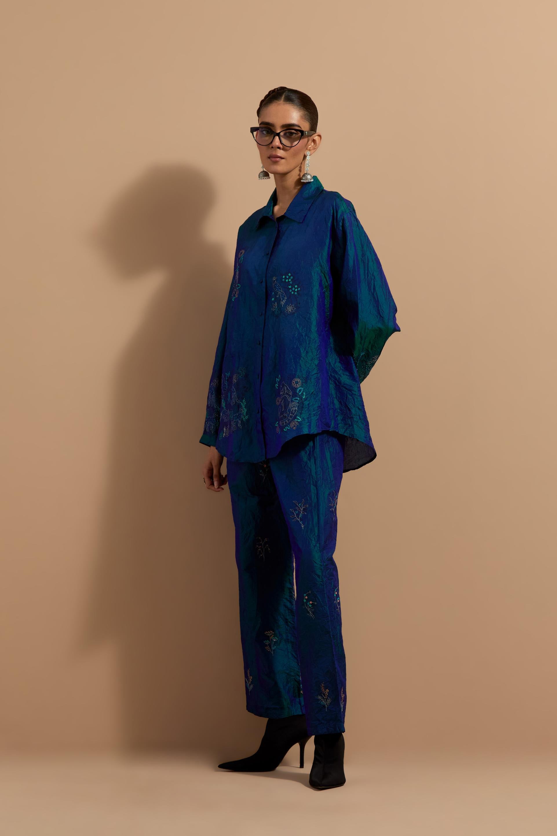 Teal blue crushed silk hand block printed shirt, highlighted with multi colored thread embroidery, paired with Teal blue crushed silk hand block printed pants, highlighted with multi colored thread embroidery.