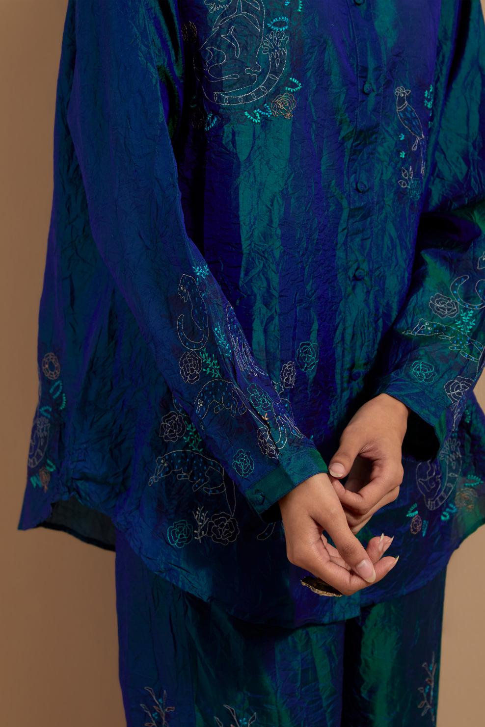 Teal blue crushed silk hand block printed shirt, highlighted with multi colored thread embroidery, paired with Teal blue crushed silk hand block printed pants, highlighted with multi colored thread embroidery.