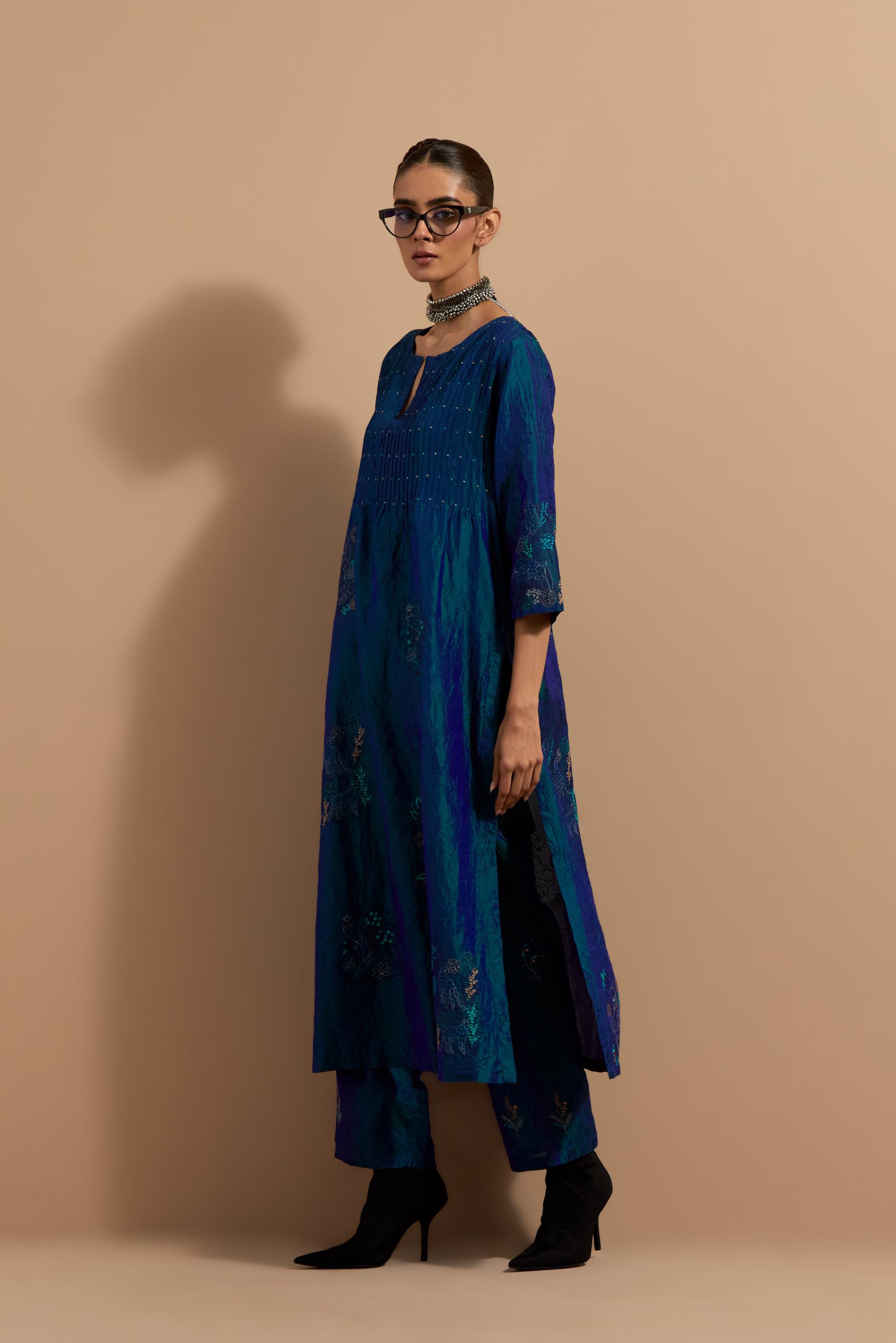Teal blue crushed silk hand block printed kurta set with pin tucks at yoke, highlighted with multi colored thread embroidery.