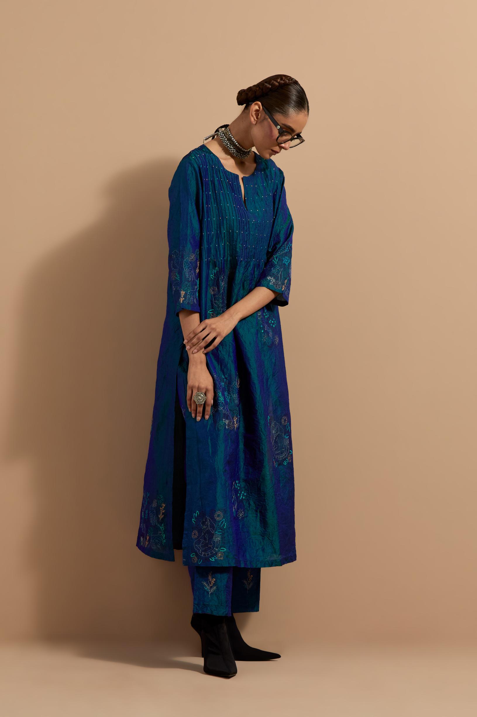 Teal blue crushed silk hand block printed kurta set with pin tucks at yoke, highlighted with multi colored thread embroidery.