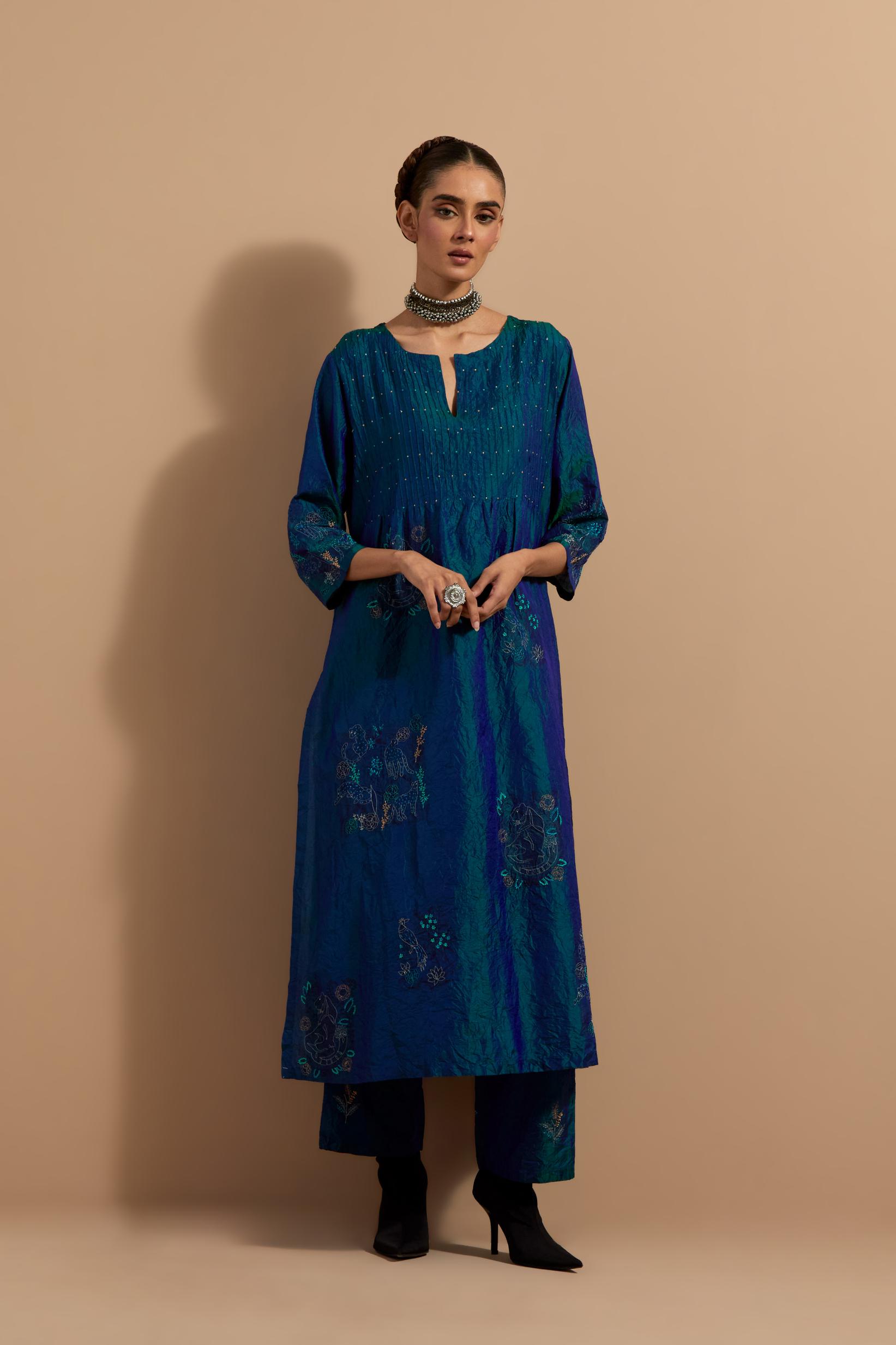 Teal blue crushed silk hand block printed kurta set with pin tucks at yoke, highlighted with multi colored thread embroidery.