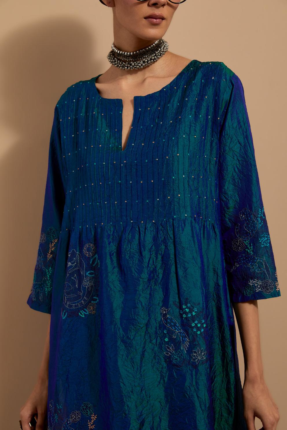 Teal blue crushed silk hand block printed kurta set with pin tucks at yoke, highlighted with multi colored thread embroidery.
