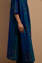 Teal blue crushed silk hand block printed kurta set with pin tucks at yoke, highlighted with multi colored thread embroidery.