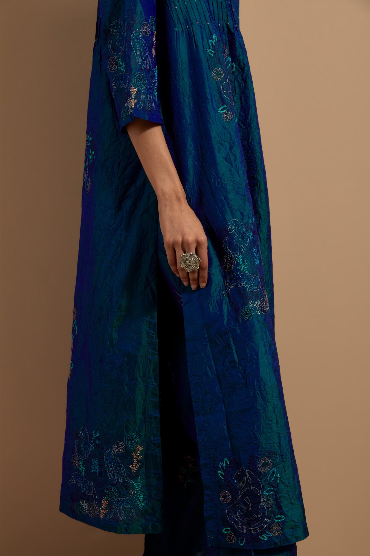 Teal blue crushed silk hand block printed kurta set with pin tucks at yoke, highlighted with multi colored thread embroidery.