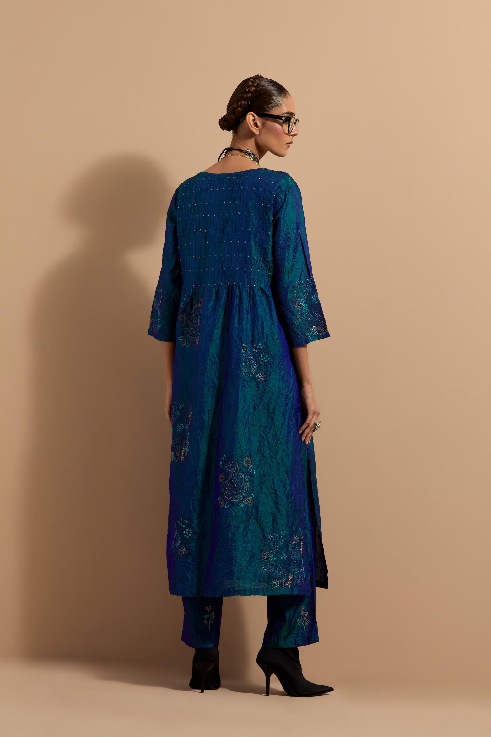 Teal blue crushed silk hand block printed kurta set with pin tucks at yoke, highlighted with multi colored thread embroidery.