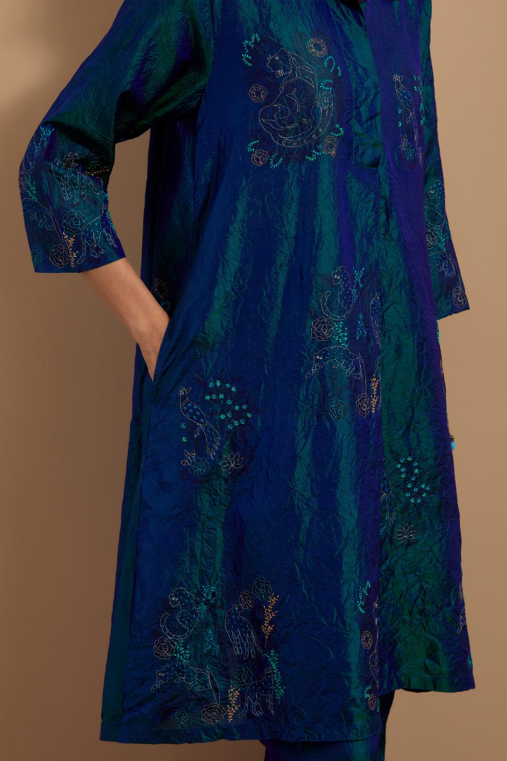 Teal blue crushed silk A-line short kurta set with hand block print, highlighted with multi colored thread embroidery.