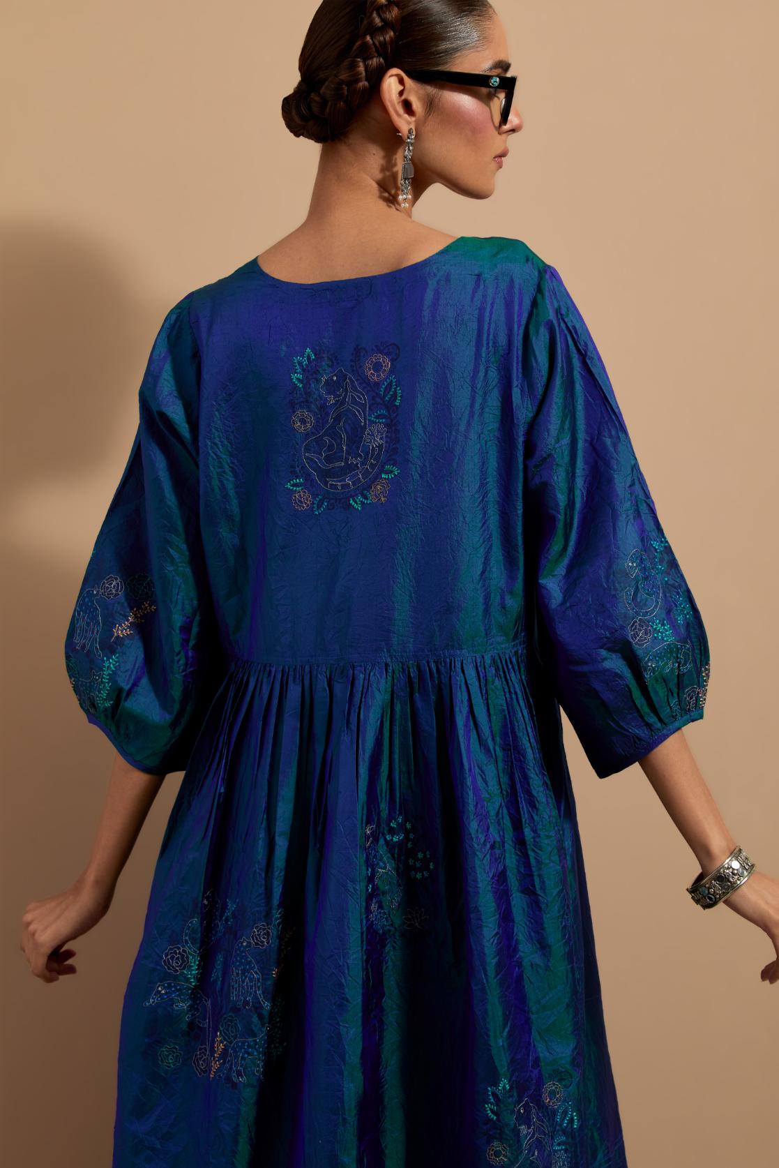 Teal blue crushed silk hand block printed long dress, highlighted with multi colored thread embroidery, paired with Mauve hand crushed block printed silk stole with quilted embroidery and beaded tassels.