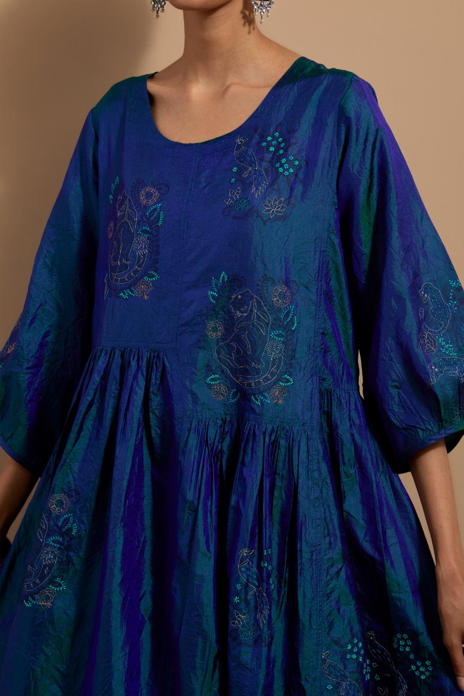 Teal blue crushed silk hand block printed long dress, highlighted with multi colored thread embroidery, paired with Mauve hand crushed block printed silk stole with quilted embroidery and beaded tassels.