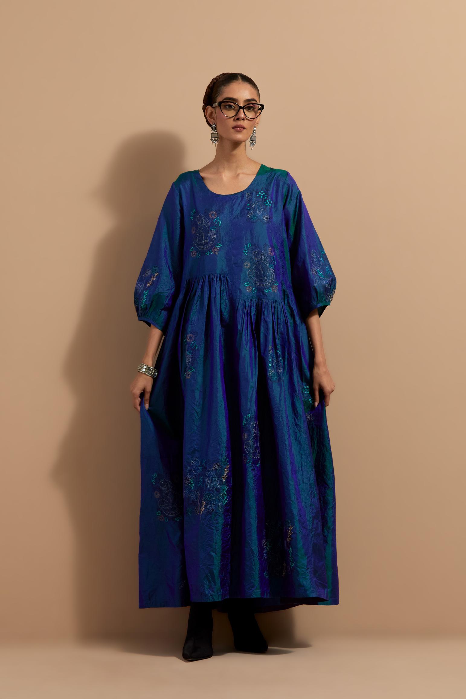 Teal blue crushed silk hand block printed long dress, highlighted with multi colored thread embroidery, paired with Mauve hand crushed block printed silk stole with quilted embroidery and beaded tassels.