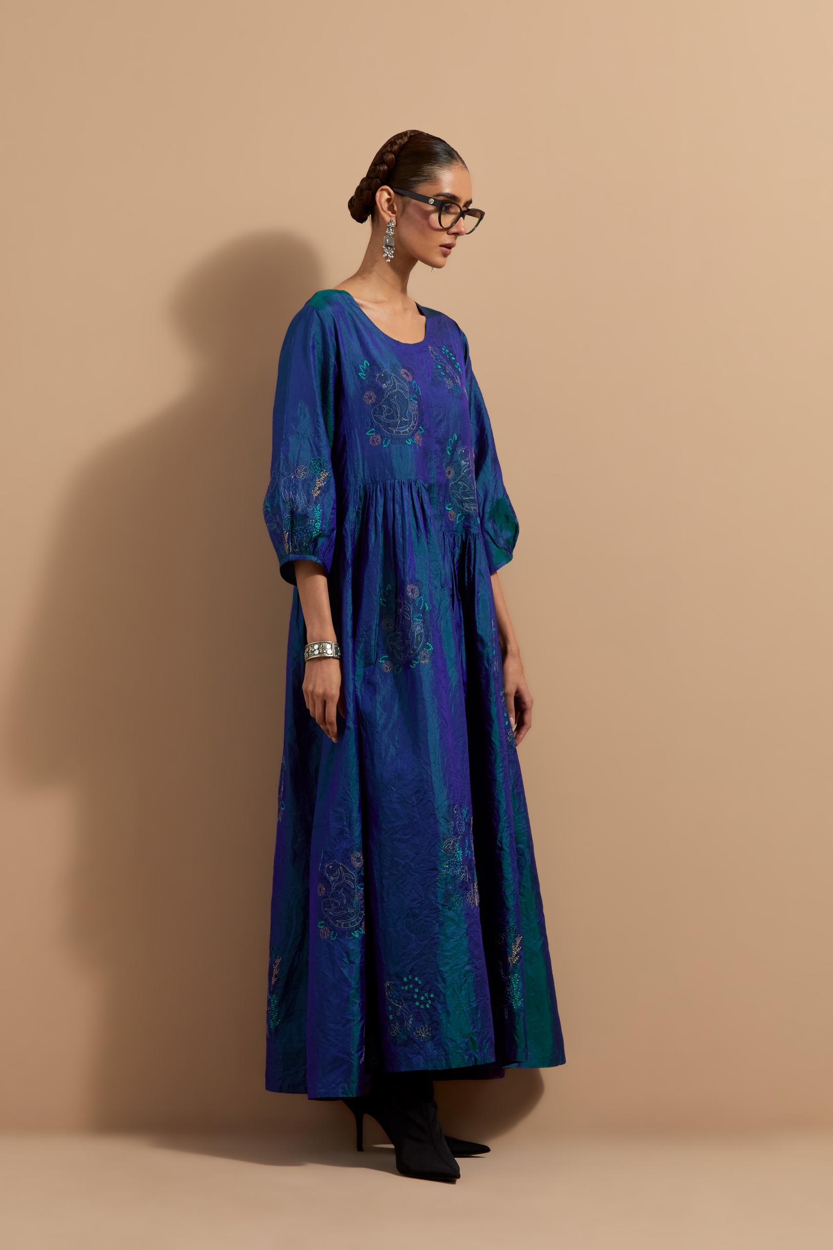 Teal blue crushed silk hand block printed long dress, highlighted with multi colored thread embroidery, paired with Mauve hand crushed block printed silk stole with quilted embroidery and beaded tassels.
