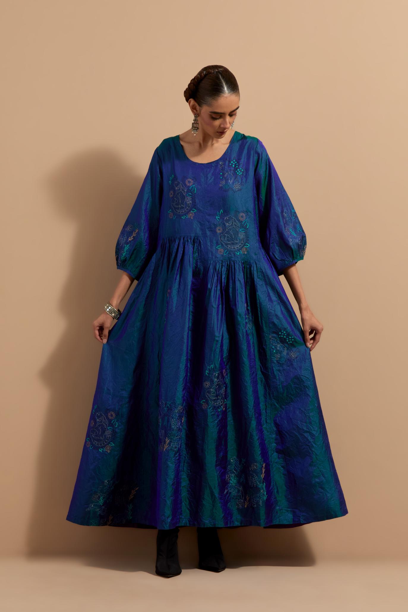 Teal blue crushed silk hand block printed long dress, highlighted with multi colored thread embroidery, paired with Mauve hand crushed block printed silk stole with quilted embroidery and beaded tassels.