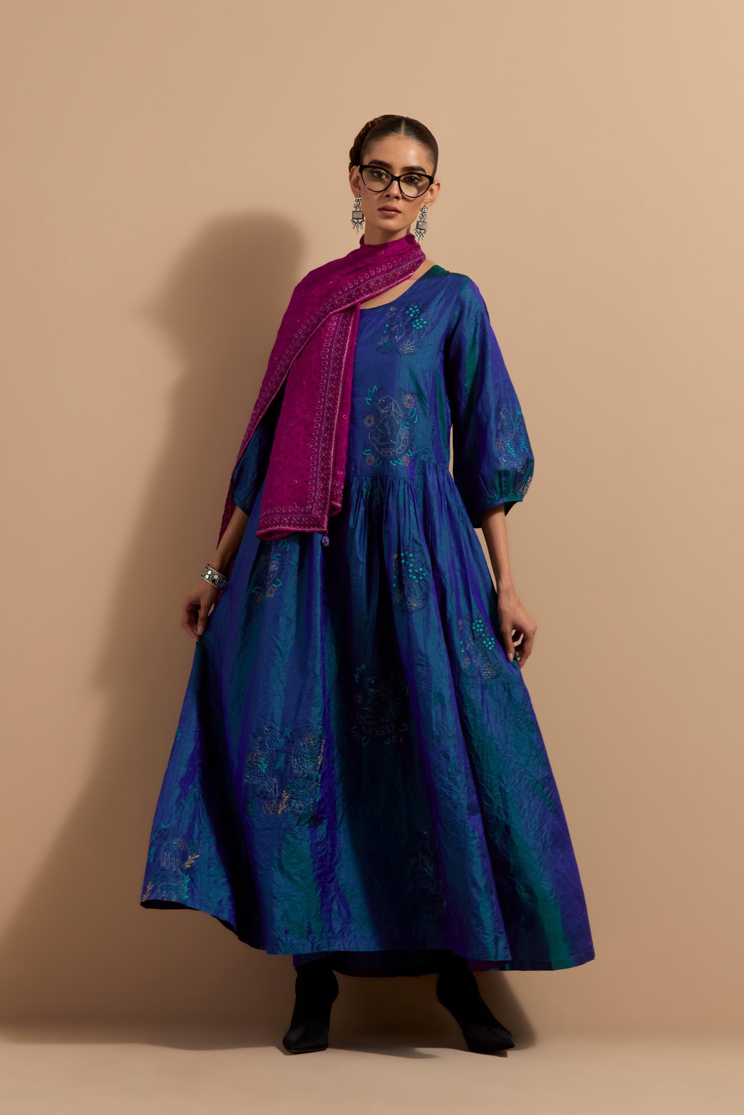 Teal blue crushed silk hand block printed long dress, highlighted with multi colored thread embroidery, paired with Mauve hand crushed block printed silk stole with quilted embroidery and beaded tassels.