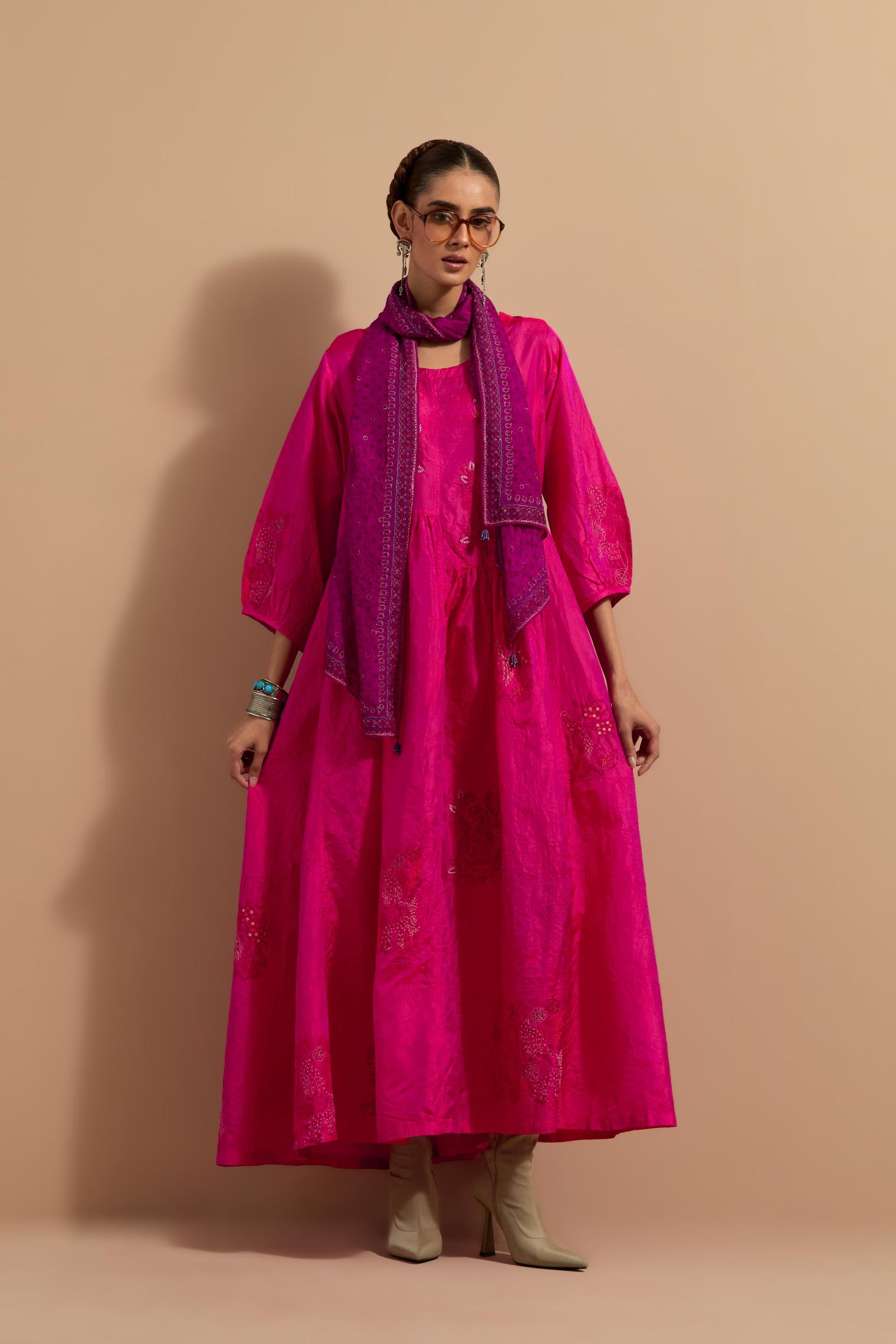 Fuchsia crushed silk hand block printed long dress, highlighted with multi colored thread embroidery, paired with Mauve hand crushed block printed silk stole with quilted embroidery and beaded tassels.