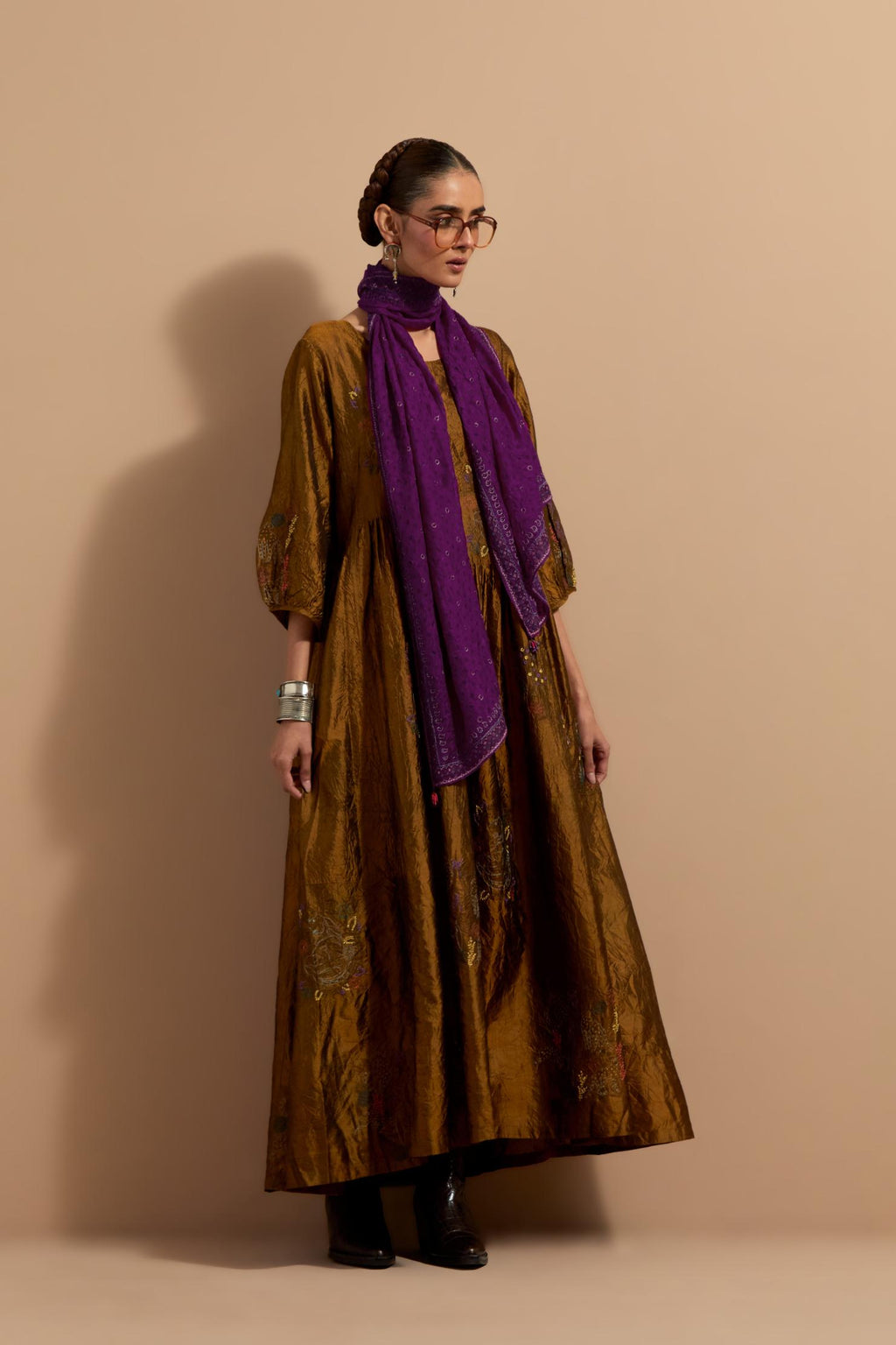 Olive crushed silk hand block printed long dress, highlighted with multi colored thread embroidery, paired with Purple hand crushed block printed silk stole with quilted embroidery and beaded tassels.
