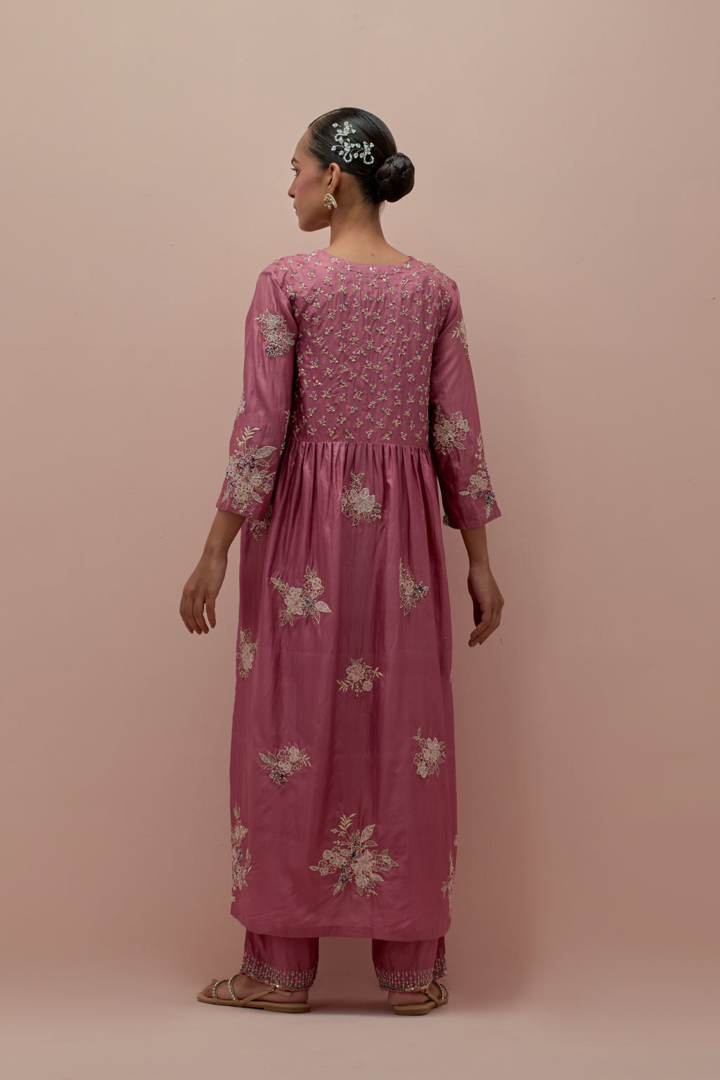 Salmon pink silk kurta dress set with delicate embroidered flowers and hand block printed appliqué motifs, highlighted with sequins and multi-colored beads.