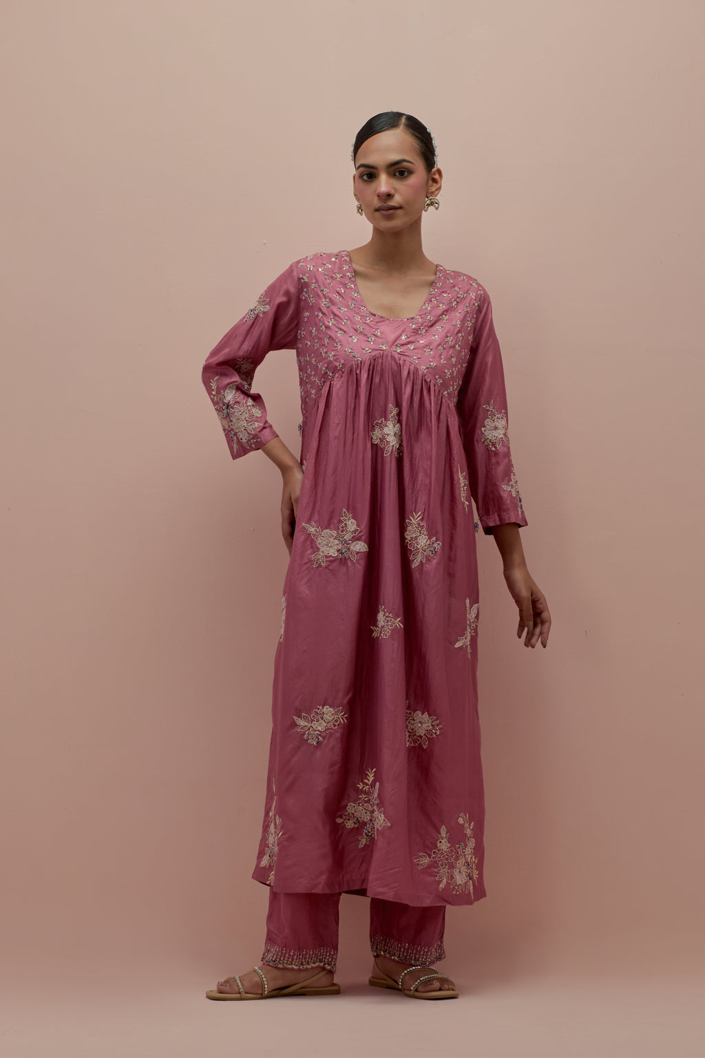 Salmon pink silk kurta dress set with delicate embroidered flowers and hand block printed appliqué motifs, highlighted with sequins and multi-colored beads.