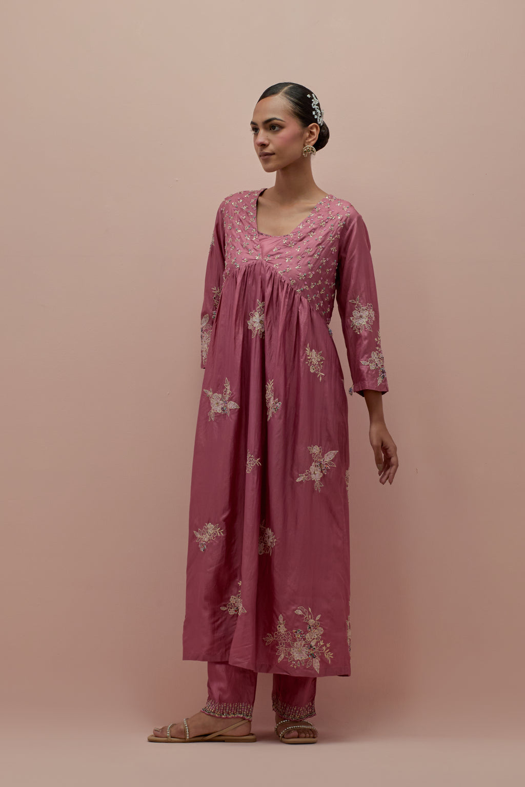 Salmon pink silk kurta dress set with delicate embroidered flowers and hand block printed appliqué motifs, highlighted with sequins and multi-colored beads.