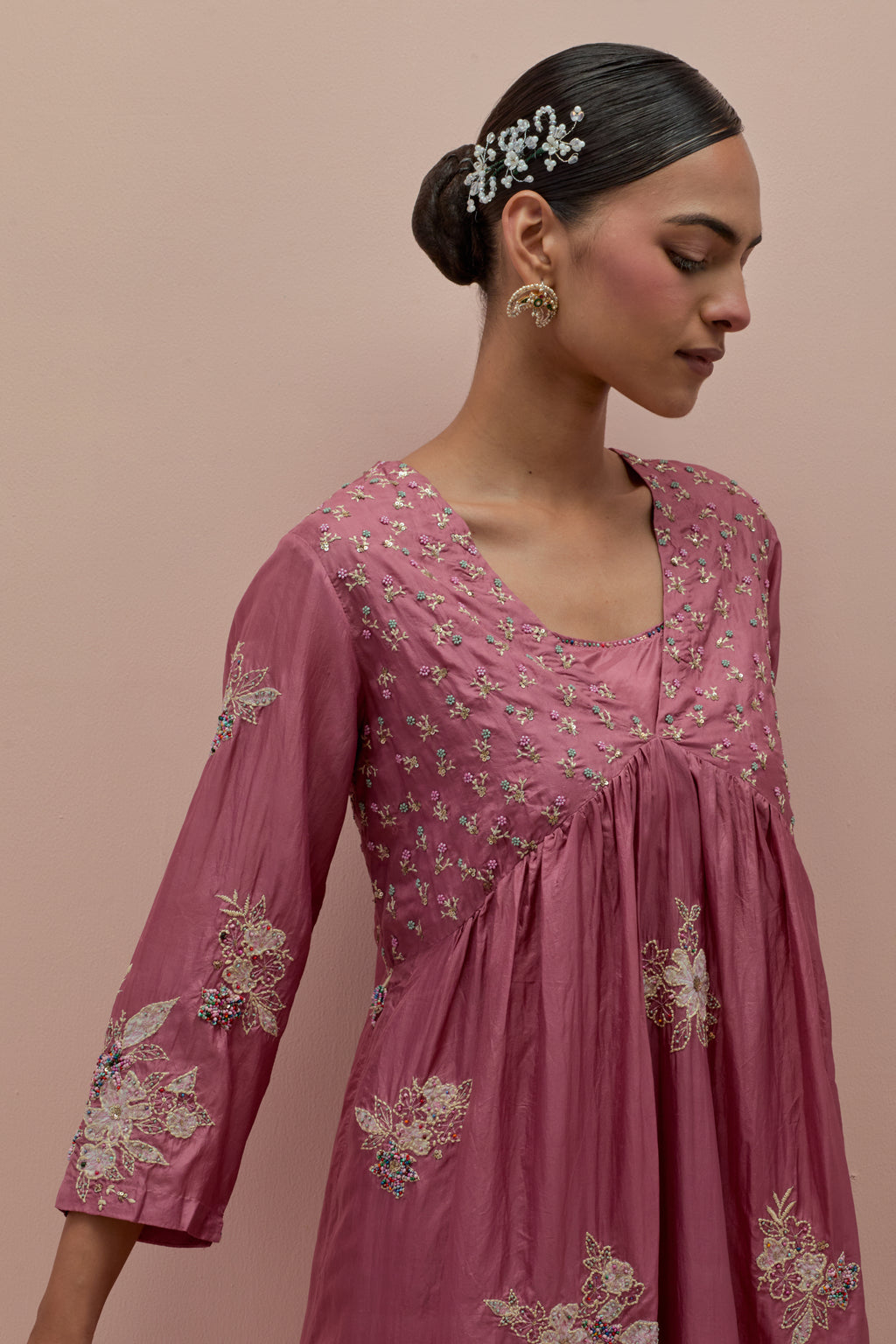 Salmon pink silk kurta dress set with delicate embroidered flowers and hand block printed appliqué motifs, highlighted with sequins and multi-colored beads.