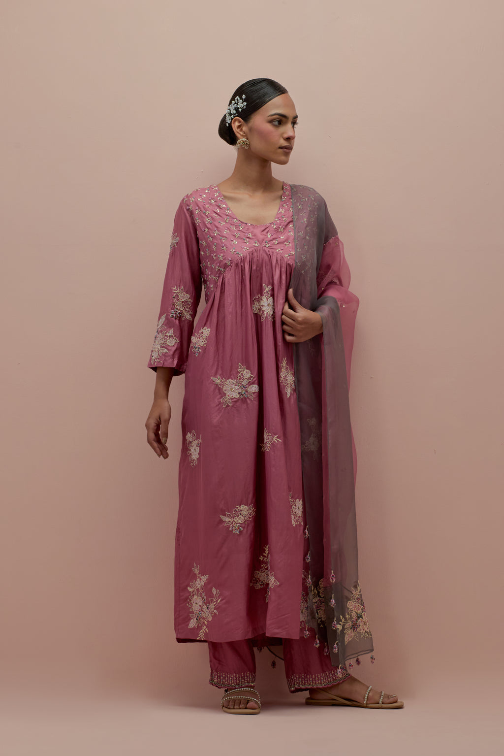 Salmon pink silk kurta dress set with delicate embroidered flowers and hand block printed appliqué motifs, highlighted with sequins and multi-colored beads.