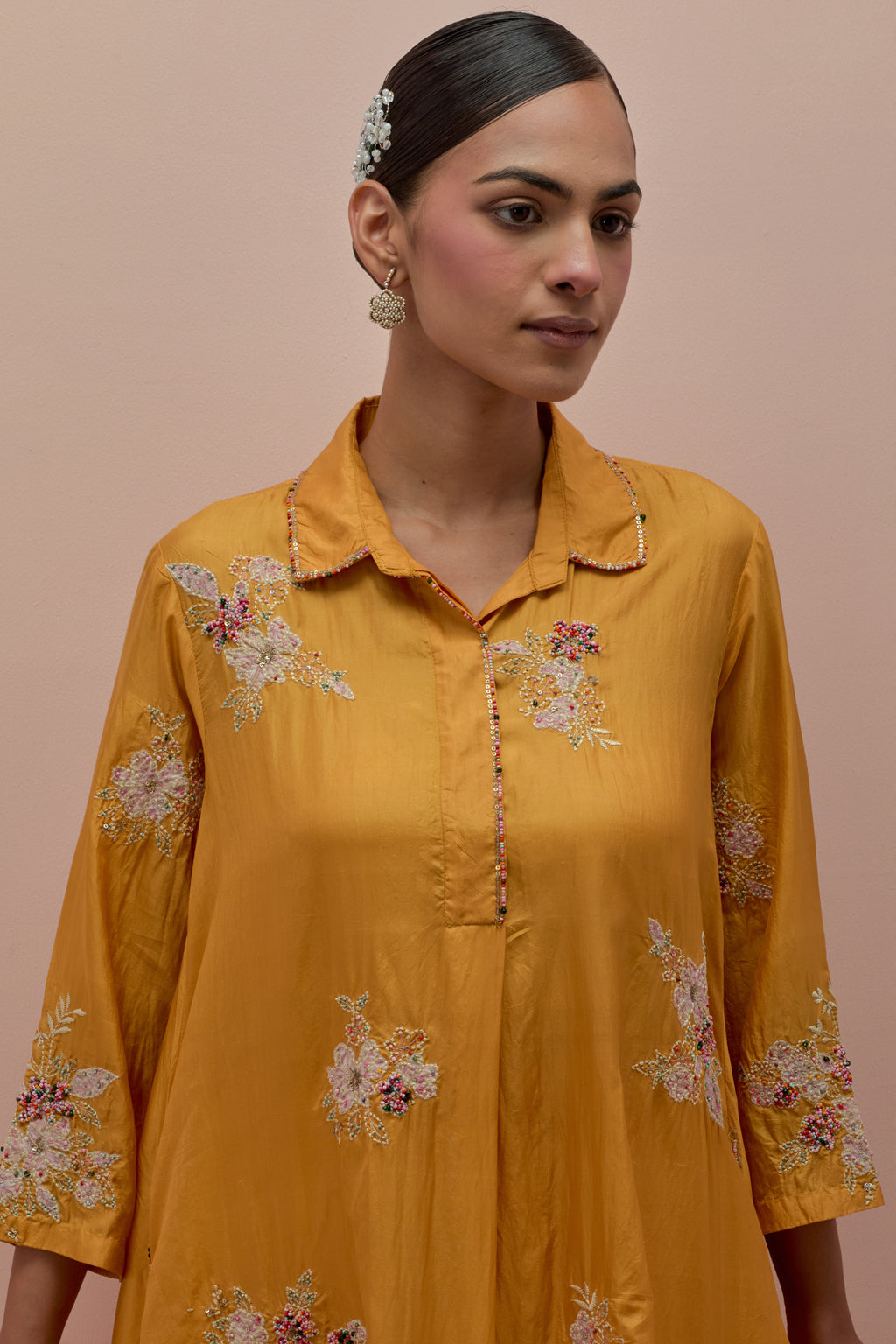 Amber silk short shirt-kurta set with all-over appliqué flowers, highlighted with sequins and multi-colored beads.