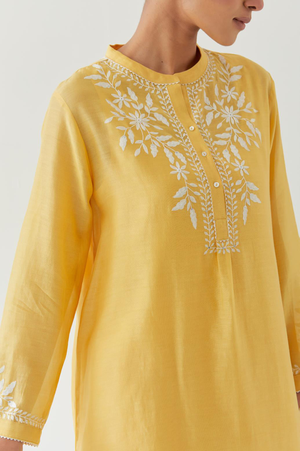 Yellow silk chanderi straight short kurta set with off white thread embroidery.