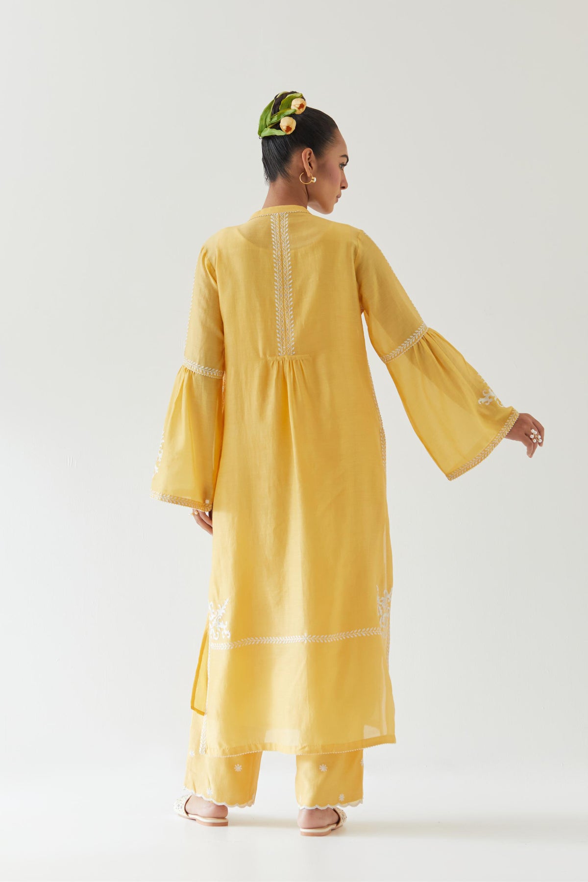 Yellow silk chanderi straight kurta set with long bell sleeves, highlighted with off white thread embroidery.
