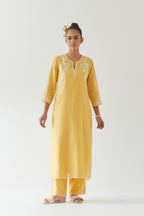 Yellow silk chanderi straight kurta set highlighted with off white thread embroidery.