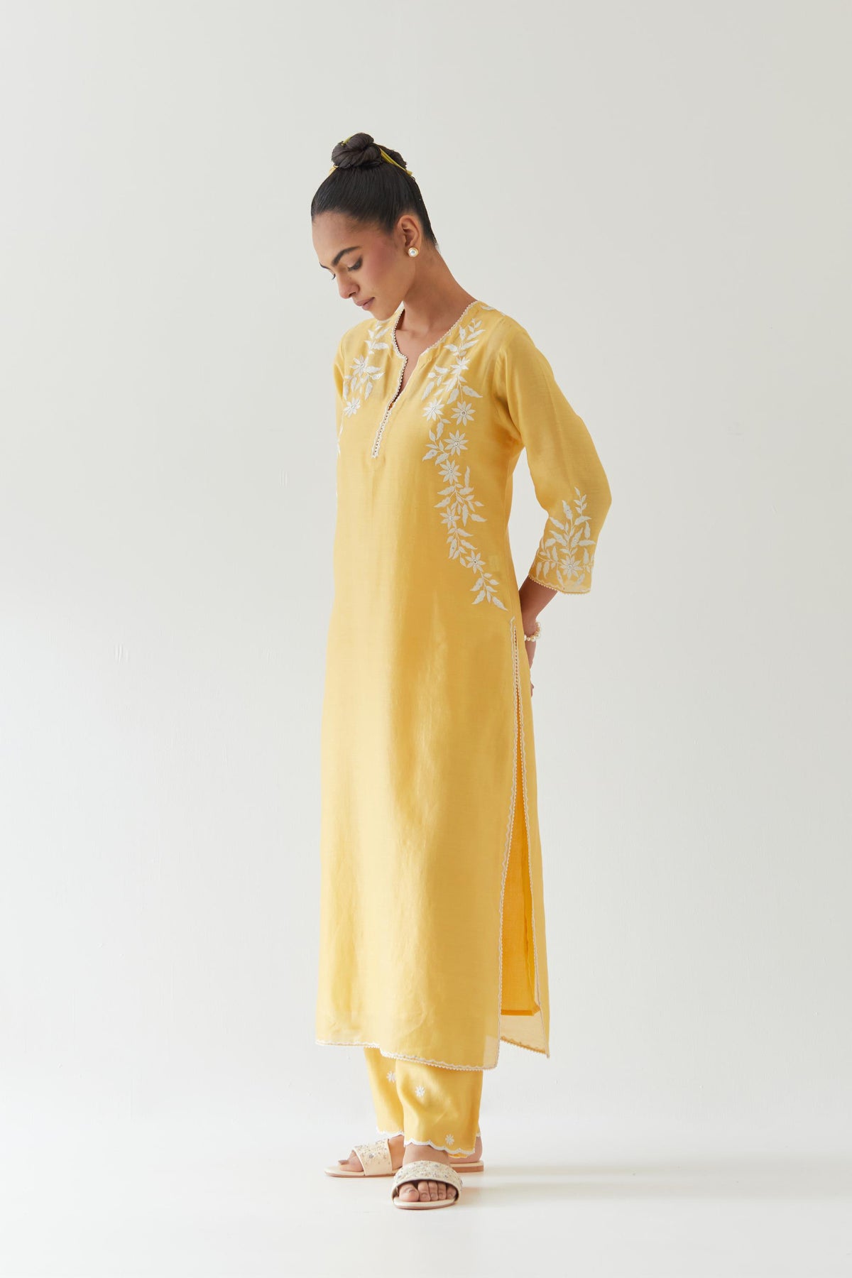 Yellow silk chanderi straight kurta set highlighted with off white thread embroidery.