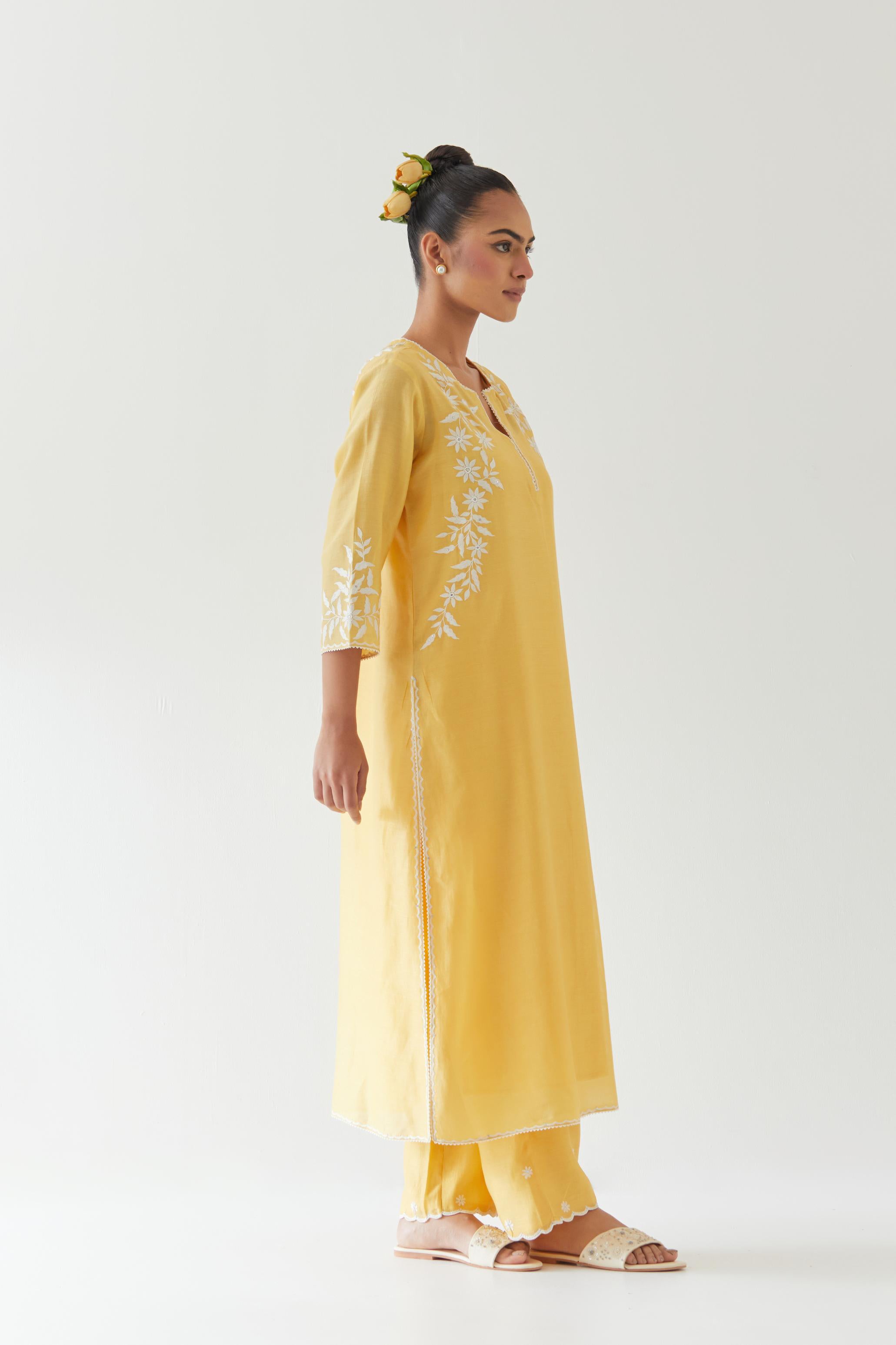 Yellow silk chanderi straight kurta set highlighted with off white thread embroidery.